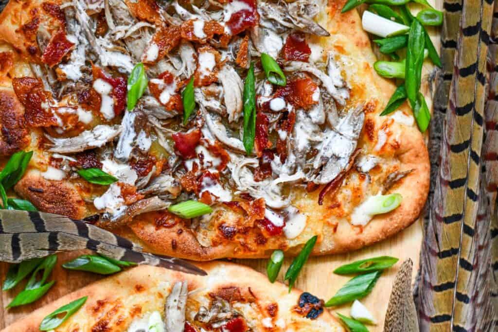 Pheasant Pizza. A great flatbread pizza recipe with bacon, cheese, green onions, and Alabama White Sauce.