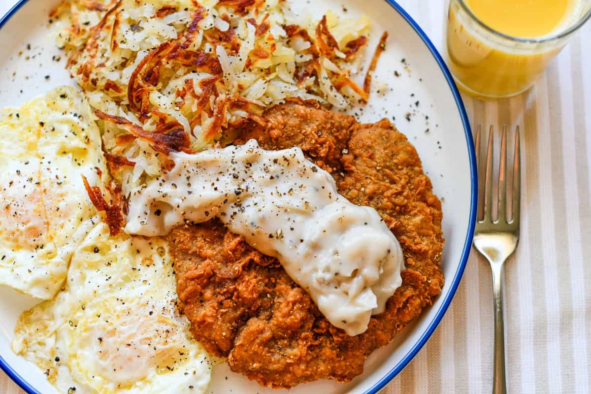 Chicken Fried Venison Steak and White Gravy Eggs Hashbrowns OJ by Jeff Benda