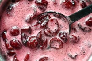 Cooking sweet cherries in a saucepan to make jam