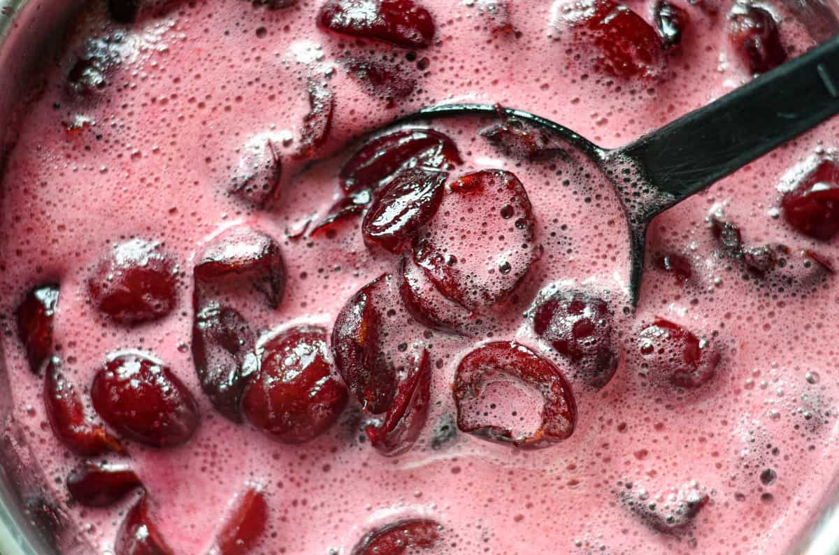 Cooking sweet cherries in a saucepan to make jam