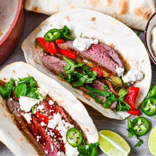 Deer Fajitas with onion, peppers, cilantro, queso fresco, limes, jalapenos, all on flour tortillas.