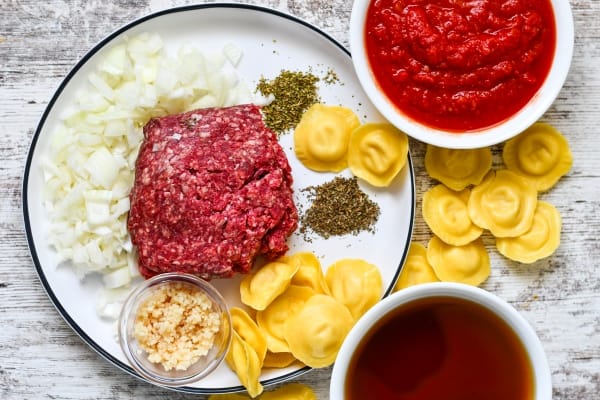 Venison Ravioli Soup Ingredients including ground venison, onion, minced garlic, dried basil, dried oregano, crushed tomatoes, venison broth, and refrigerated ravioli.