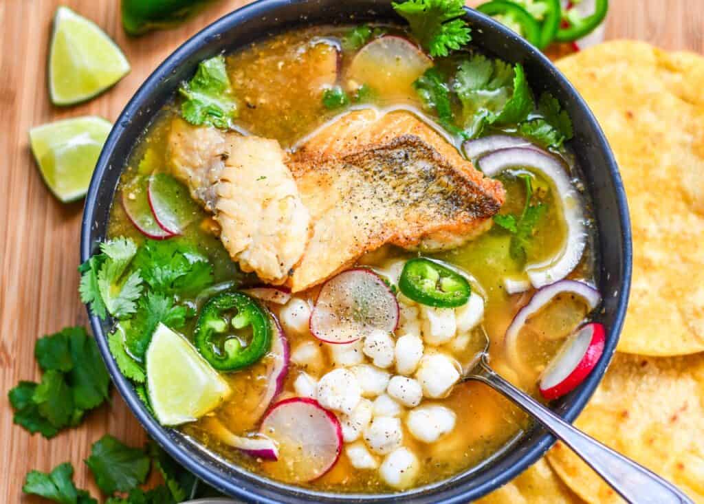 Green Pozole Recipe with Fish, Hominy, Radish, Cilantro, and Jalapenos.