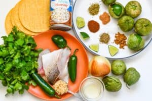 Fish Pozole Soup Ingredients including walleye, jalapenos, minced garlic, cilantro, corn tortillas, hominy, yellow onion, tomatillos, and seasonings