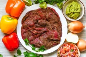 Snow Goose Fajitas Ingredients including goose breast, onion, bell peppers, lime, cilantro, guacamole, and pico de gallo.