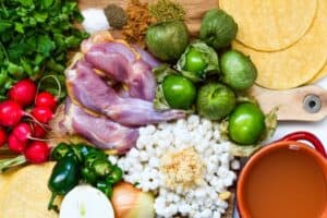 Green Pozole Ingredients including tomatillos, onion, jalapenos, hominy, cilantro, chicken broth, lime, salt, black pepper, cumin, Mexican oregano.