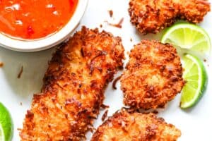 Crispy Coconut Crusted Fish with Easy Sweet Chili Sauce and garnished with lime wedges. I used American Paddlefish for this recipe, but you can use another firm white fish.