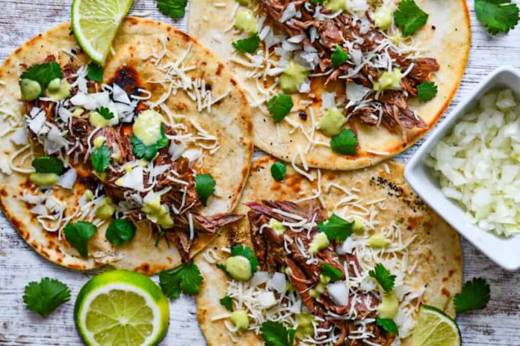 Venison Carnitas Tacos with onion, lime, cilantro, and creamy avocado