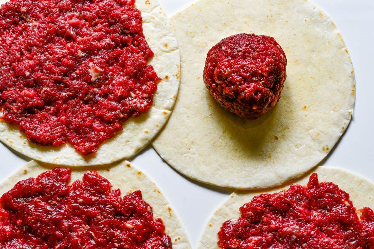 ressing seasoned ground venison into flour tortillas