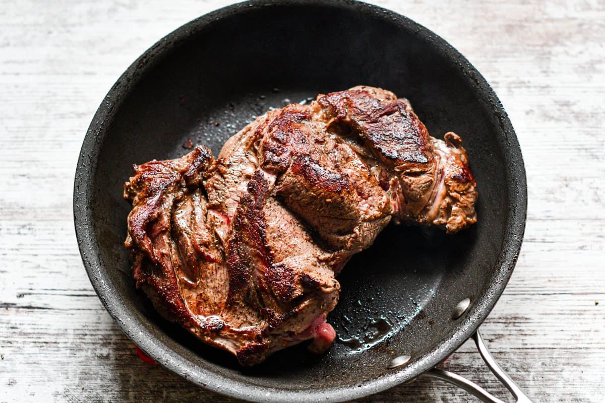 Deer roast seared in pan before slow cooking